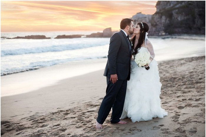 Romantic destination wedding portrait of a couple kissing on a beach