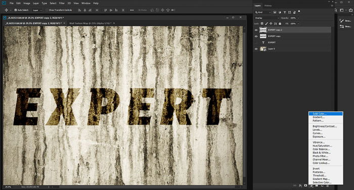 A screenshot of editing a photo of a textured grunge wall with the word 'expert' using the displacement map photoshop