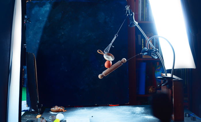 Setup for shooting a still life of a hand balancing kitchen utensils and flour clouds - creative still life photos