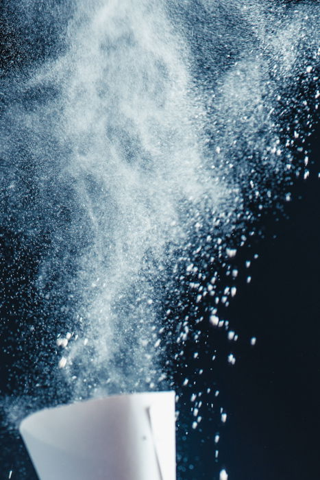 Setup for shooting a still life of a hand balancing kitchen utensils and flour clouds - creative still life photos