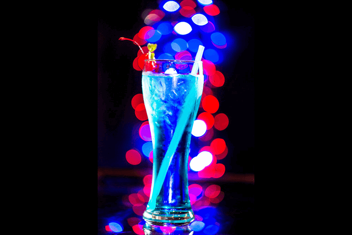 A blue cocktail with blurry bokeh light background 