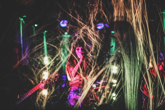 Atmospheric nightclub photography portrait of a female performer in low light