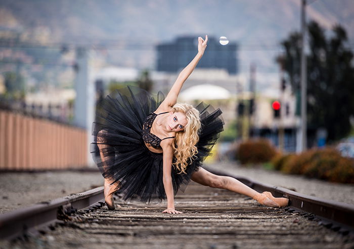 An atmospheric dance portrait of a female dancer on train tracks