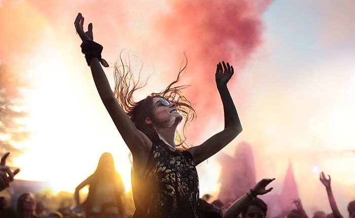 A portrait of a female dancing at an outdoor event at sunset