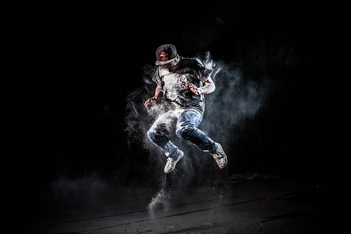 A cool flour dance photography portrait of a male dancer against black background