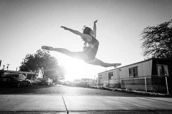 A black and white dance photography shot of a female ballet dancer mid jump