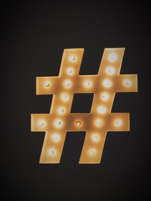 A golden lighted Instagram hashtag on black background