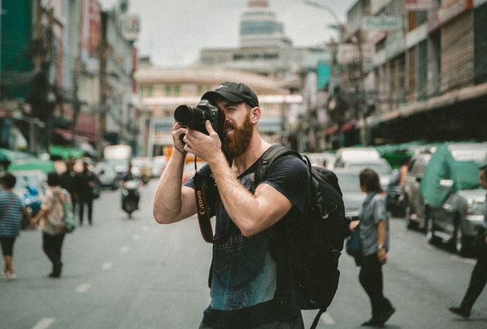 A photographer shooting street photography with his dominant eye