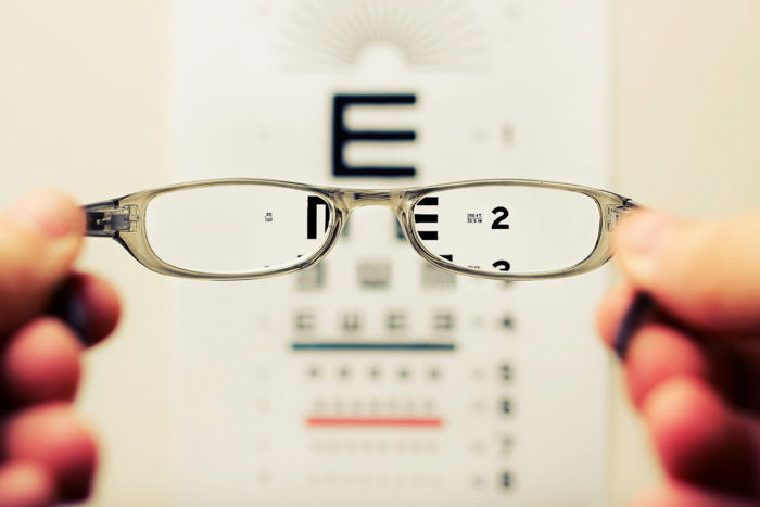 An opticians eye test chart seen through a pair of eyeglasses 