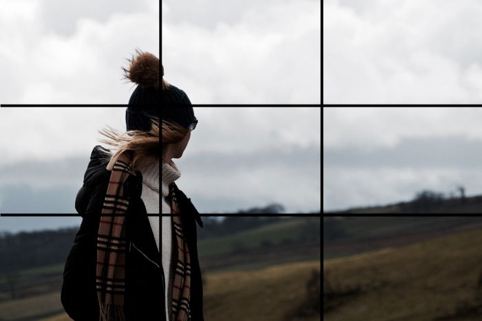 A portrait of a female model walking in a countryside area with the rule of thirds grid overlayed