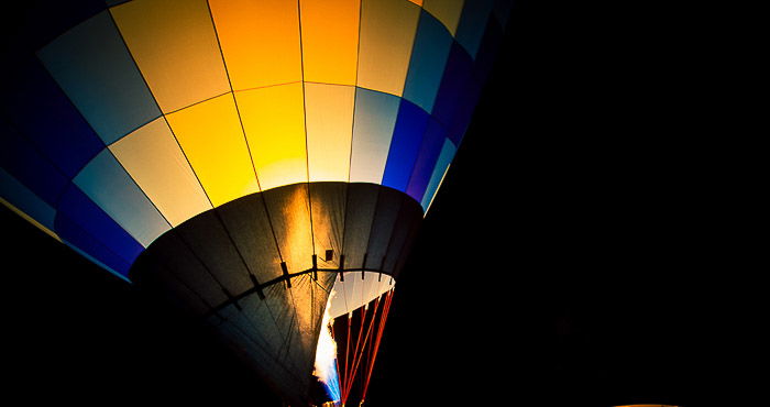 A close up photo of a colorful hot air balloon at night