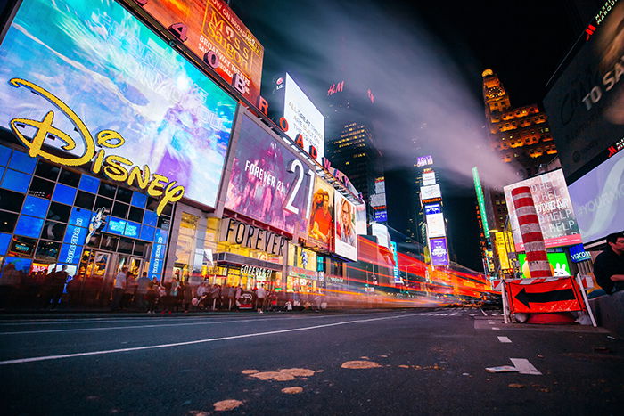 A night street scene filled with the neon lights of store fronts - neon photography tips