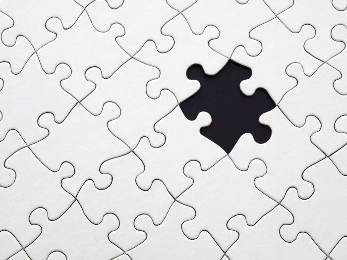 A stock image of a white jigsaw puzzle with one piece missing - stock images