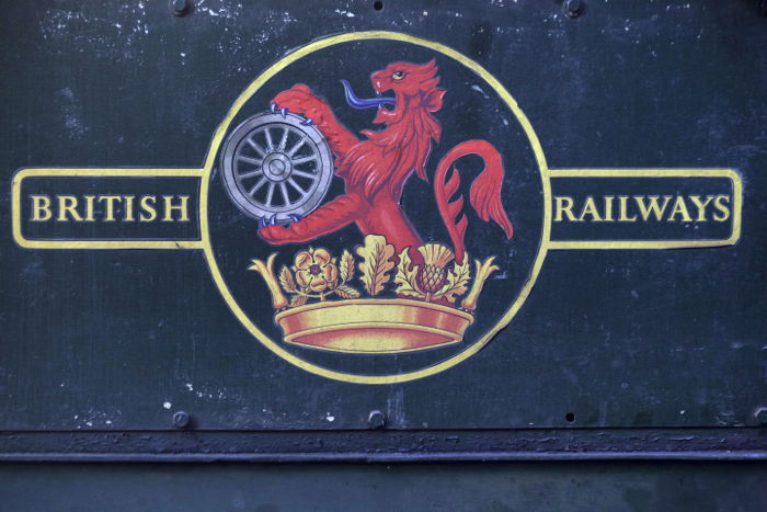 A British railways sign on the side of a steam train. 