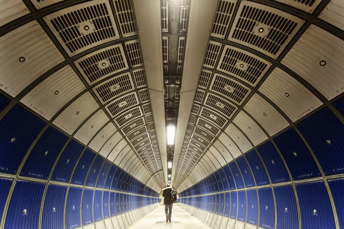 A man walking through a tunnel on jubilee line of the London underground