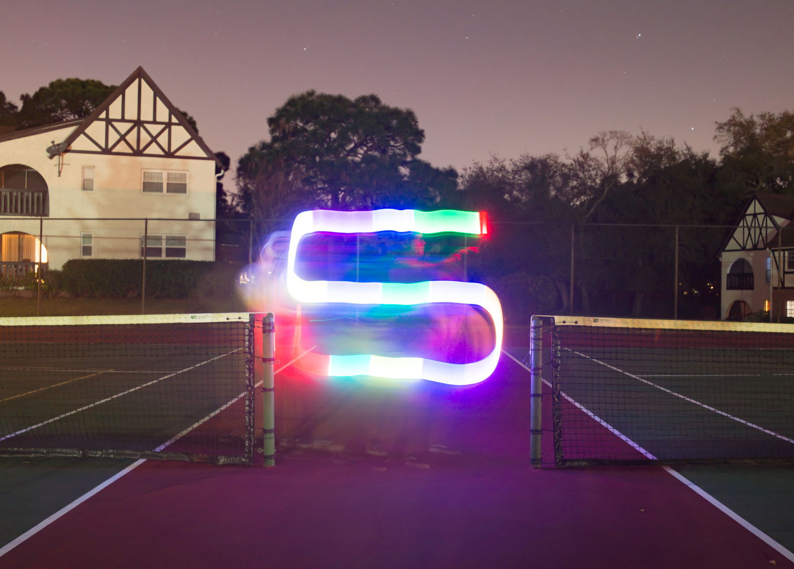 A light painting of the letter S between two tennis courts as night for creative lighting ideas