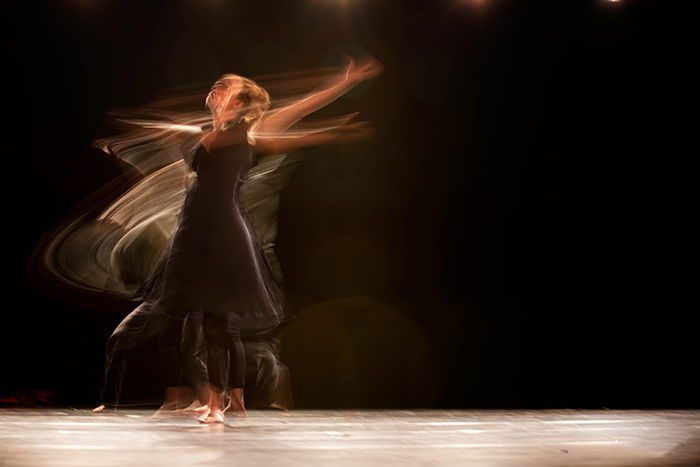 An artistic blurry portrait of a ballet dancer onstage - ballet photography tips