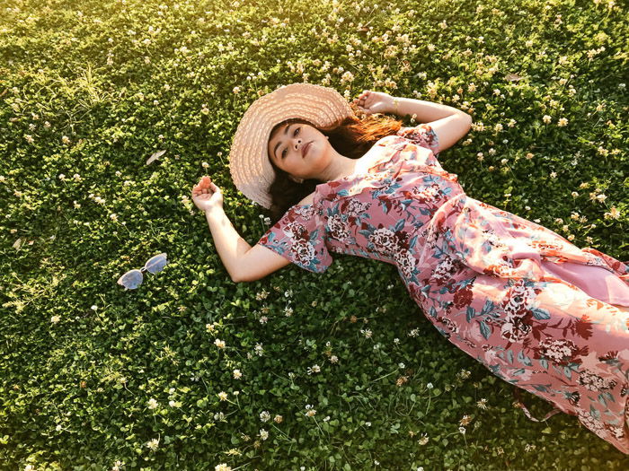 A portrait of a female model lying down outdoors shot from high camera angles