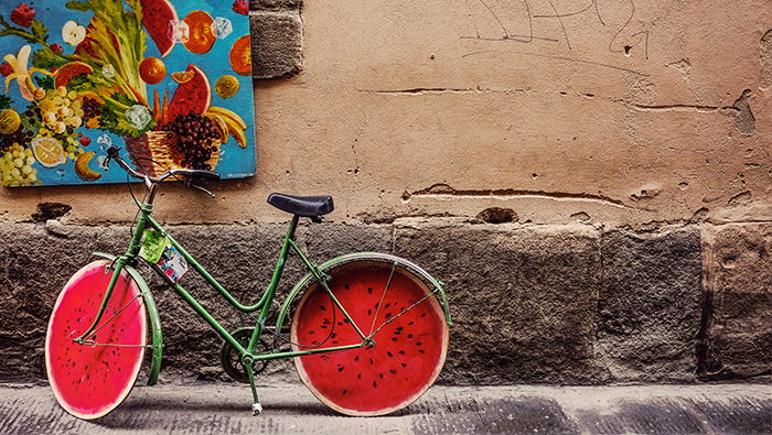 A street photo of a bicycle with watermelon painted wheels - conceptual photography ideas