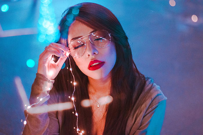 Atmospheric portrait of a female model holding fairy lights shot using neon photography