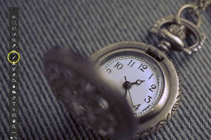 A close up product photography shot of a pocket watch edited with clone stamp tool