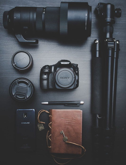 Camera lenses, tripod and other photography equipment of a black table