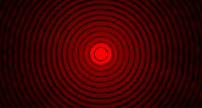 A black background with concentric, red circles and a red dot in the center.