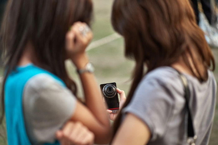 Two girls taking a selfie with a camera - shallow vs deep depth of field