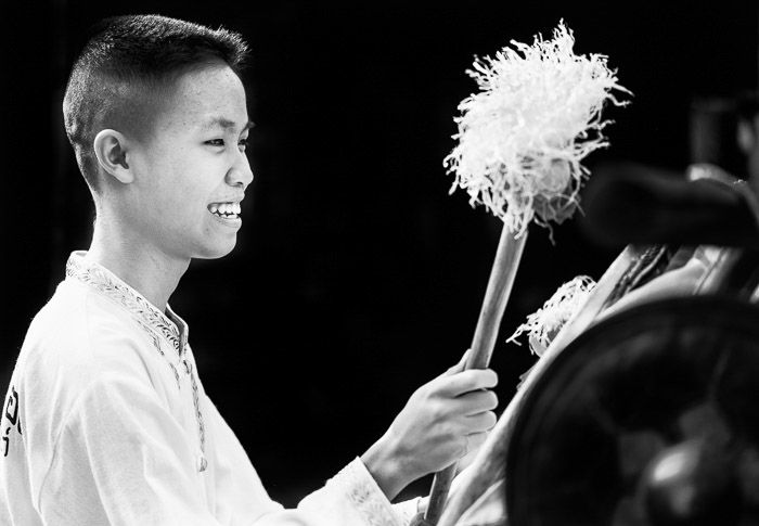 Monotone street photography portrait of a Thai Traditional Drummer Boy at a festival - narrative photography ideas