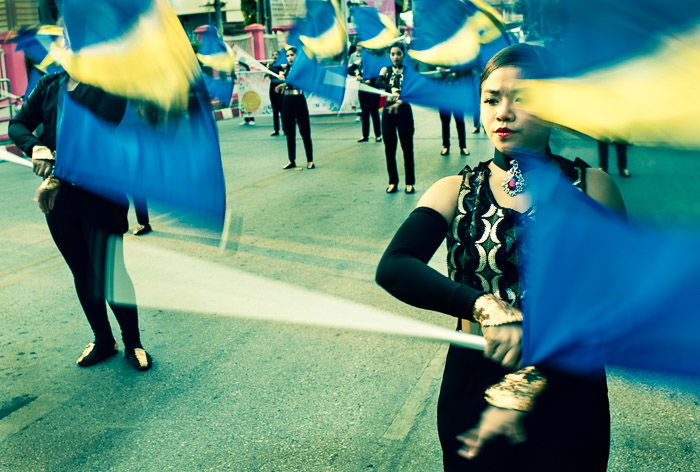 Young people perform with flags in the street as part of the annual flower parade in Chiang Mai, Thailand. Visual storytelling in photography