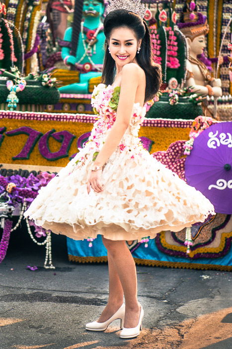 A young woman posing for a street portrait, her dress covered in real flowers. photography narrative tips