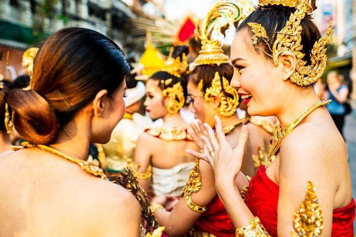 A street portrait of girls talking together while they wait for the flower parade they are taking part in to start. narrative photography ideas