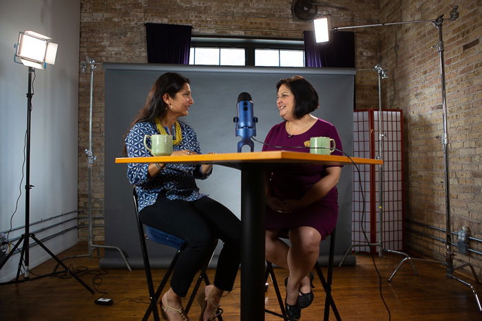 two female models posing in a professional studio with a backdrop, overhead lights and all the bells and whistles.