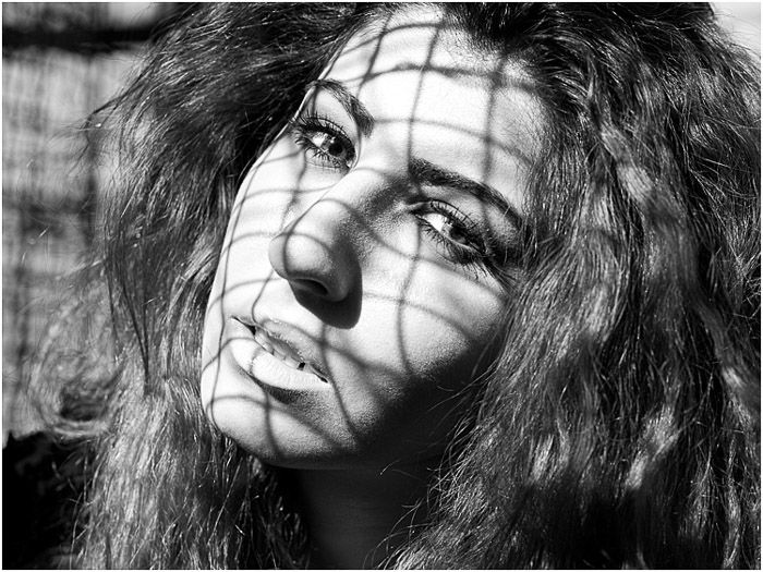 A black and white portrait of a female model posing outdoors