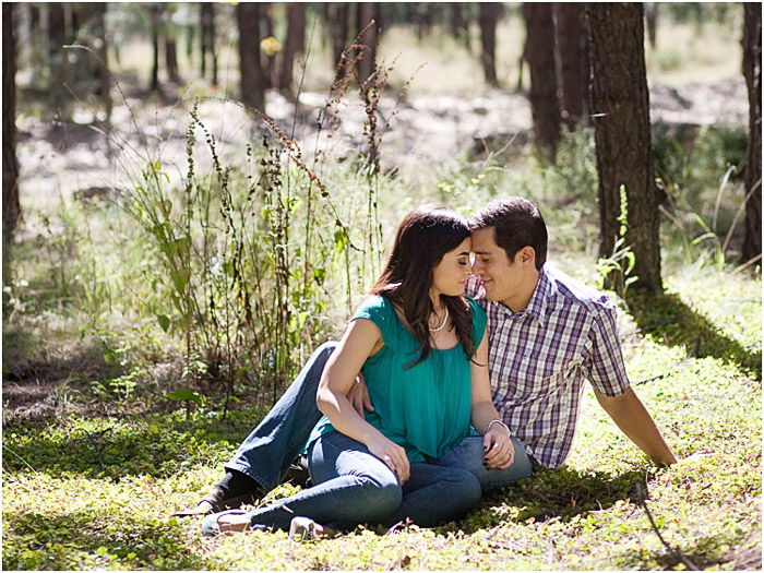 A couple posing outdoors in dappled light