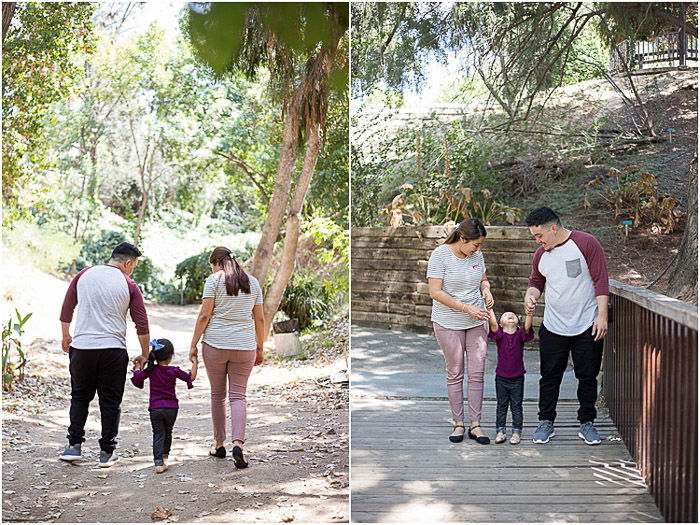 A family of three posing outdoors in dappled light