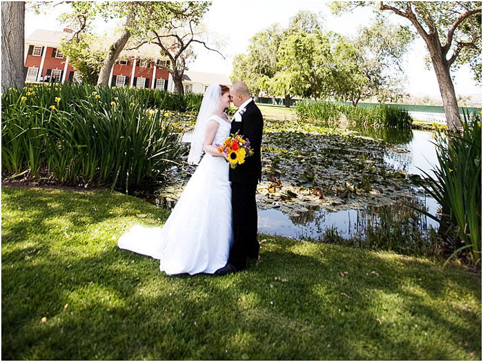 A newlywed couple posing outdoors in dappled light