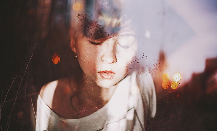 Dreamy portrait of a female model posing against a reflective surface