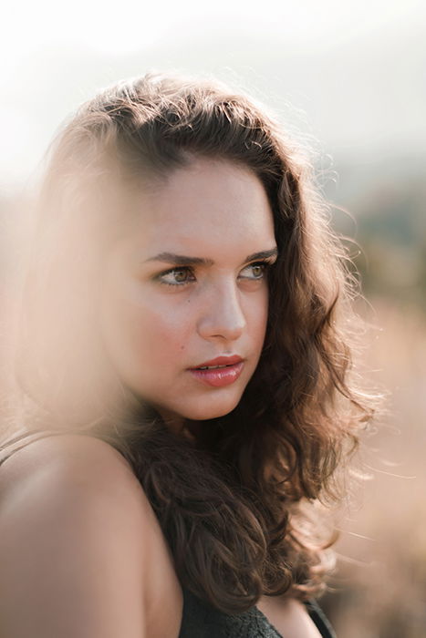 Dreamy portrait of a female model posing outdoors, featuring ethereal motion blur