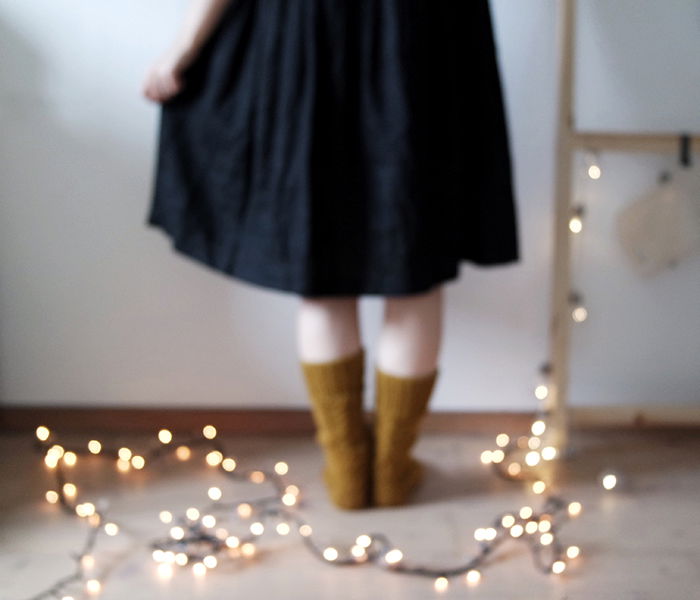 blurry indoor portrait of a female model standing in front of a string of lights - fairy light photography 