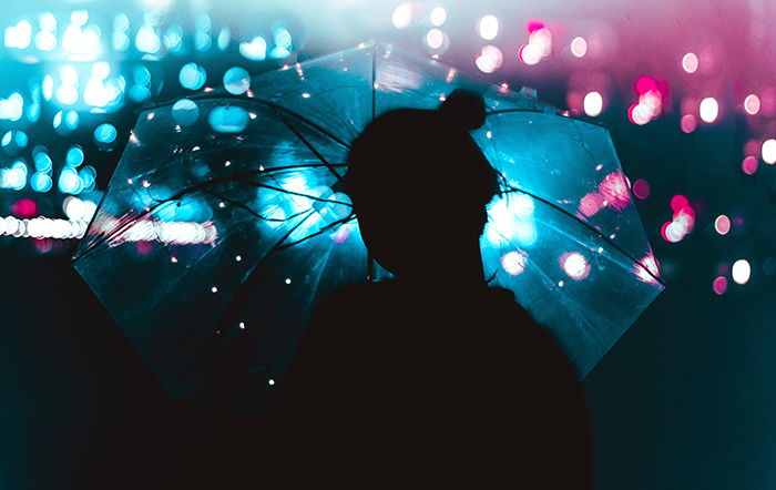 atmospheric silhouette of a female model holding an umbrella in the rain - fairy light photography 