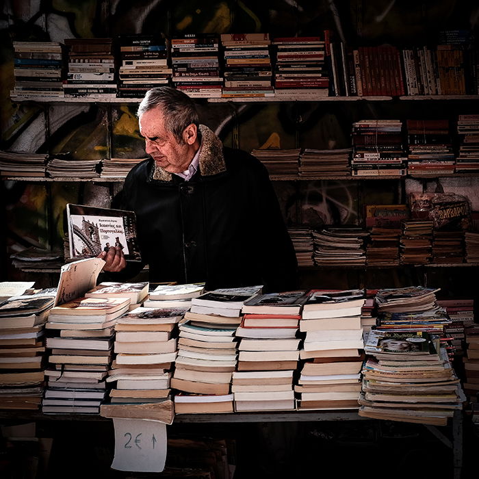 A street portrait of a man browsing books in an outdoor market - gestalt theory photography