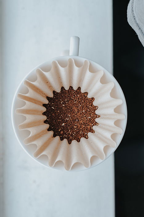 An overhead shot of a coffee filter filled with coffee grounds - Gestalt Theory photography