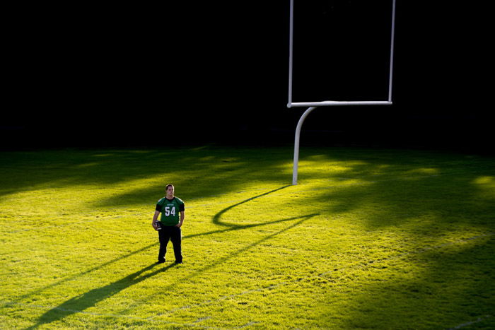 An athlete standing on a sports field in hard light - high contrast lighting