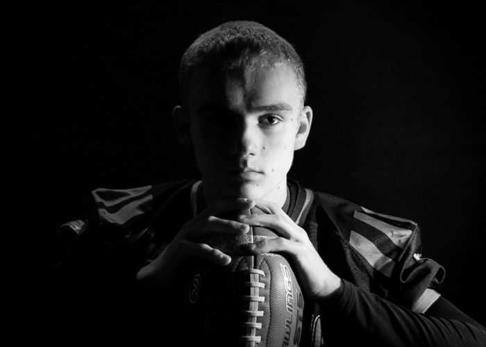 Atmospheric black and white portarit of a young boy shot using hard light photography 