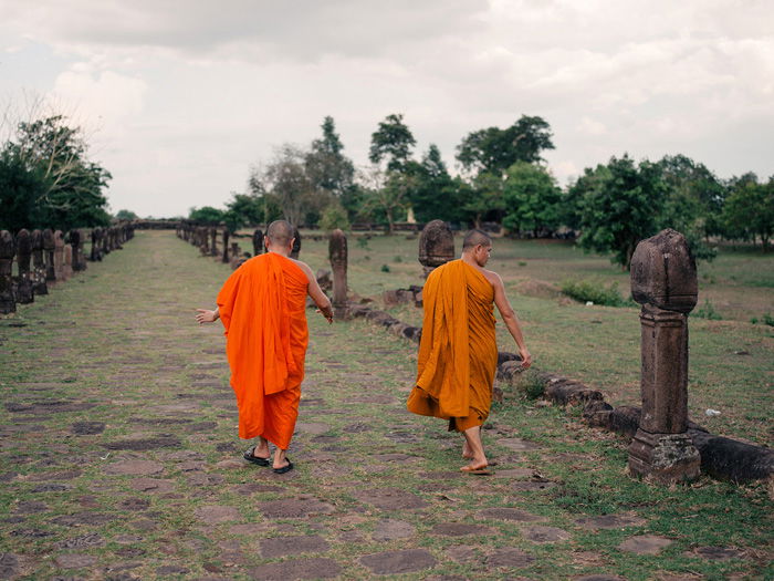 Two Buddhist monks walking through a field 