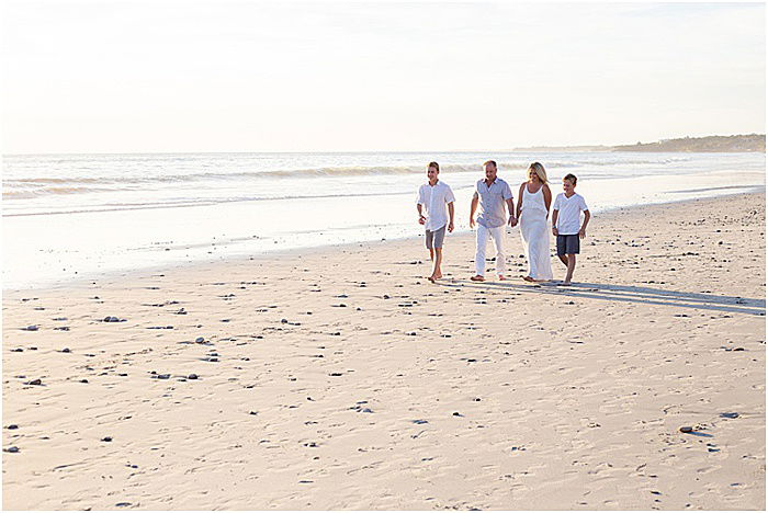 A fun and casual portrait of a family of four posing on the beach - emotional photography