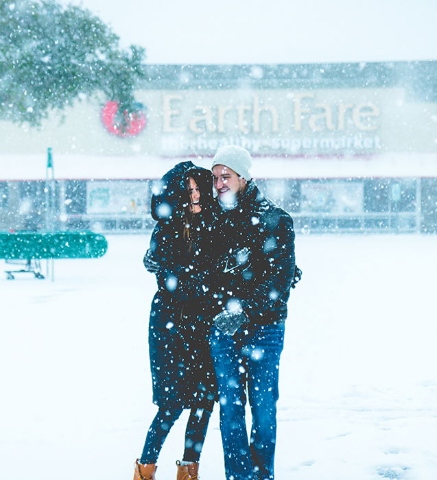 Close up winter portrait photography of a couple posing in the falling snow