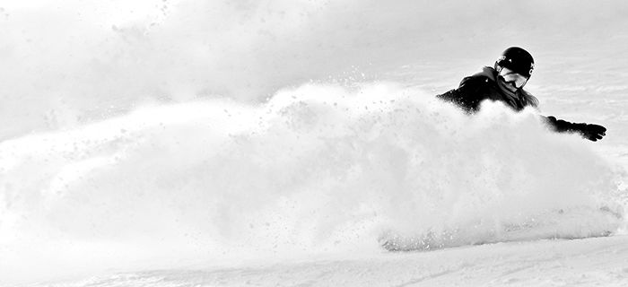 Atmospheric sports photography shot of a female snowboarder posing in action - winter portrait photography