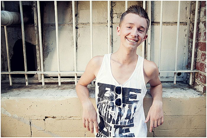 A relaxed portrait of a teenage boy posing outdoors - teenager pictures